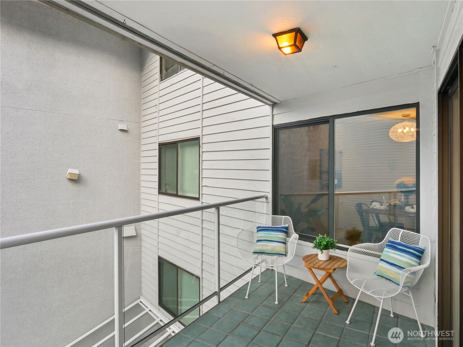 2104 Alki Avenue Southwest, Unit 306 Seattle, WA 98116 - Photo 12 of 40 a balcony with chairs and a potted plant