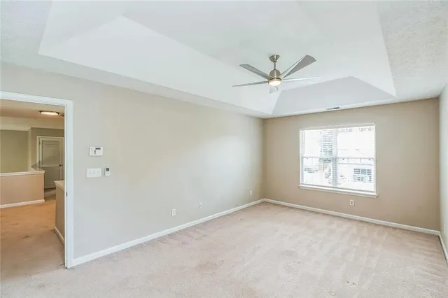 an empty room that has a window and a ceiling fan