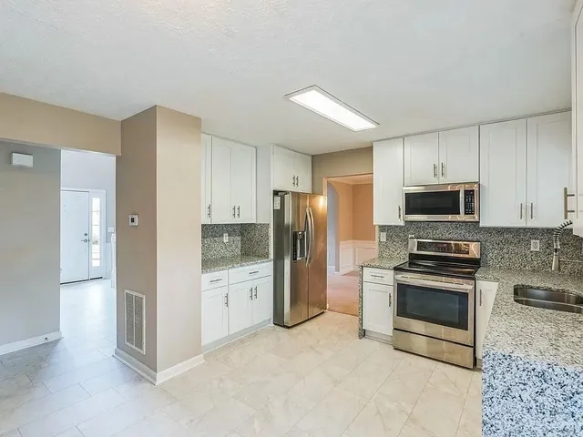 a kitchen with stainless steel appliances granite countertop a refrigerator stove and oven
