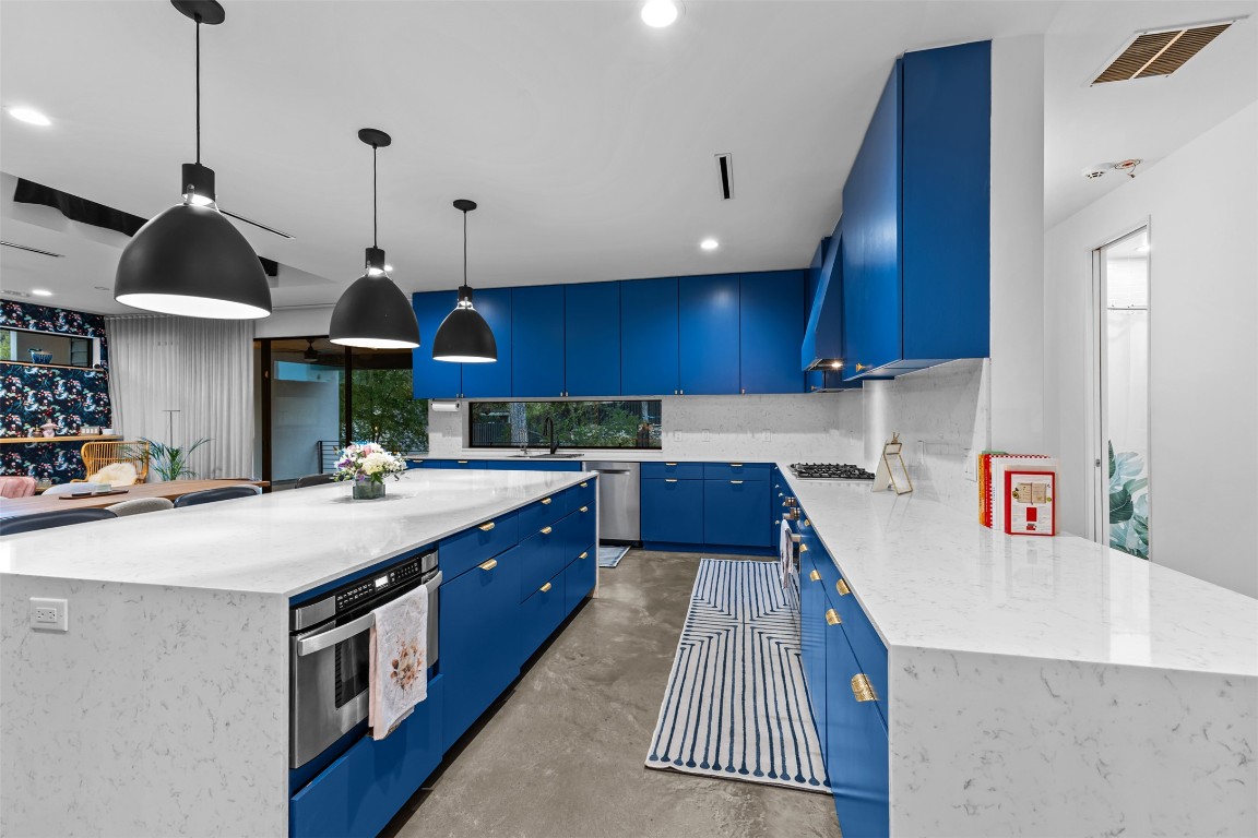 5704 Driftwood Drive Austin, TX 78731 - Photo 12 of 40 a kitchen with stainless steel appliances granite countertop a sink a stove and a wooden floors