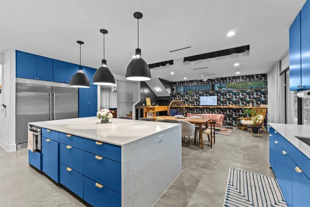 a kitchen with stainless steel appliances granite countertop a sink a stove and a wooden floors