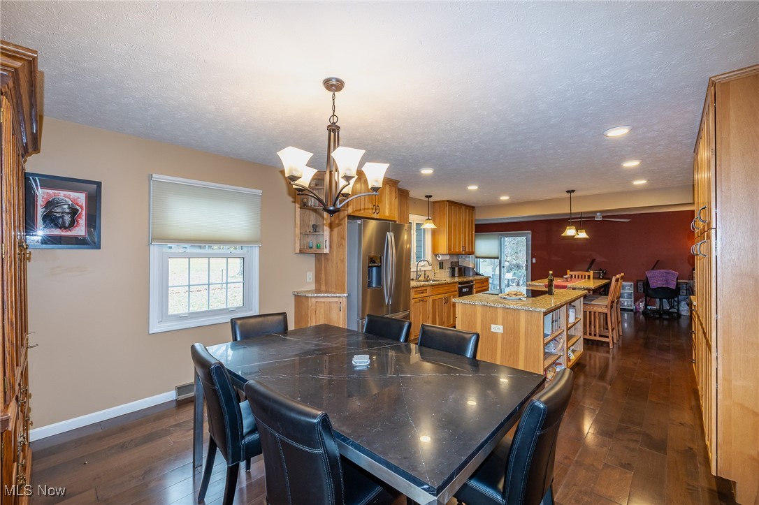 7711 Diagonal Road Kent, OH 44240 - Photo 7 of 45 Dining area with dark wood-style floors, a textured ceiling, a chandelier, a ceiling fan, and recessed lighting