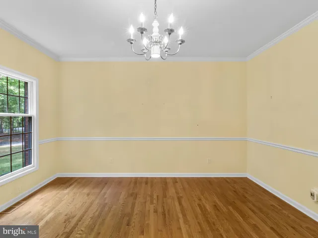 a view of a room with wooden floor and chandelier