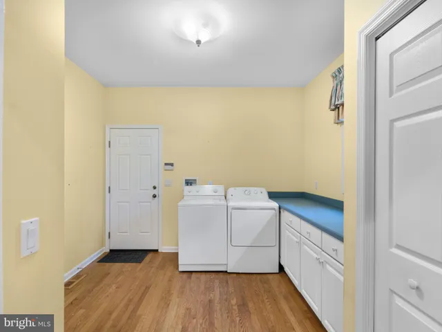 a room with a wooden floor and washer dryer