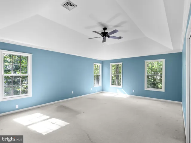 a view of a big room with windows and chandelier fan