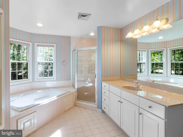 a spacious bathroom with a large tub sink and double vanity