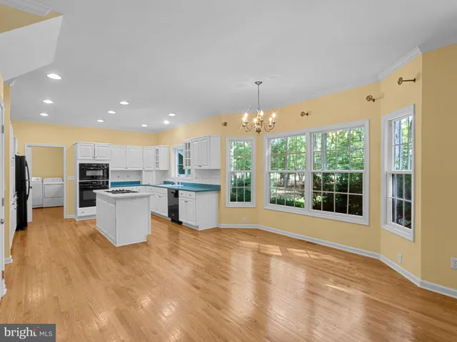 a open kitchen with white cabinets and stainless steel appliances