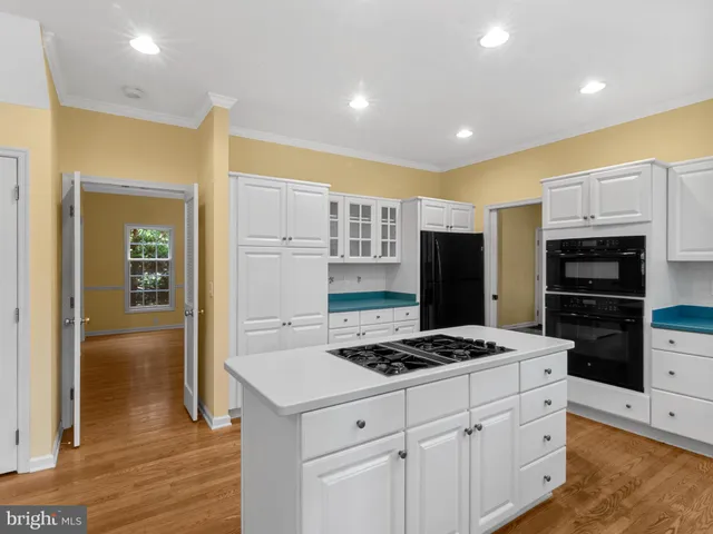 a kitchen with granite countertop a refrigerator and a stove top oven