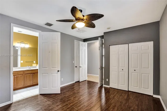 a bathroom with a granite countertop sink mirror vanity and toilet