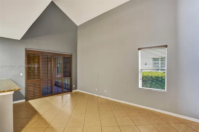 a view of an empty room with wooden floor and staircase