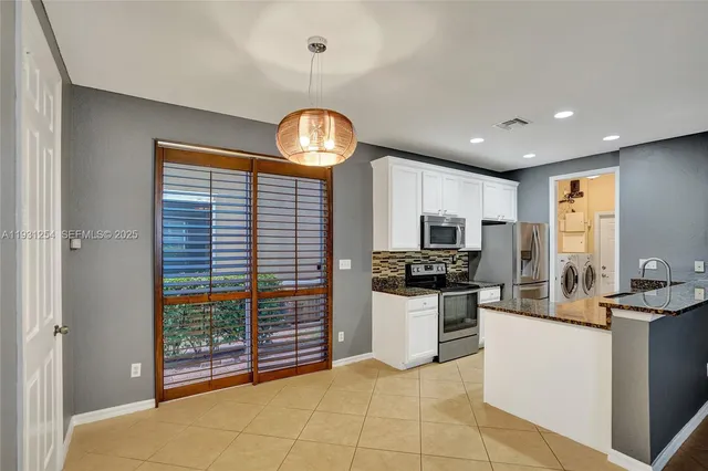 a kitchen with stainless steel appliances a sink and a refrigerator