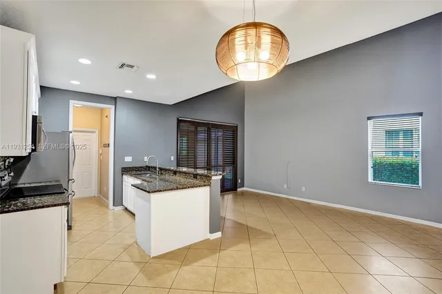 a kitchen with stainless steel appliances granite countertop a refrigerator a stove a sink and a microwave