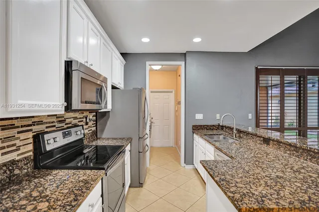 a kitchen with granite countertop a stove and a microwave