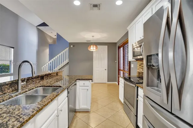 a view of a hallway with wooden floor and a bathroom
