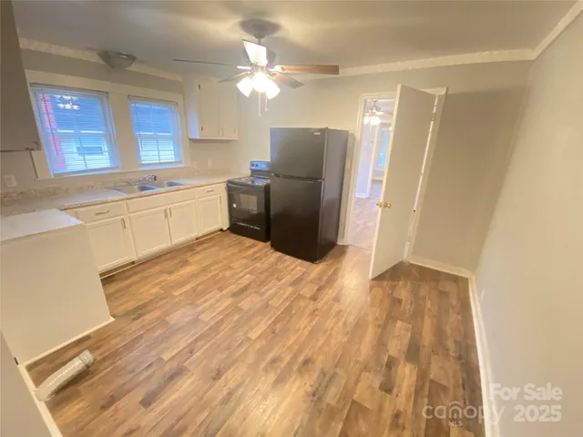 a kitchen with stainless steel appliances granite countertop a refrigerator sink and white cabinets