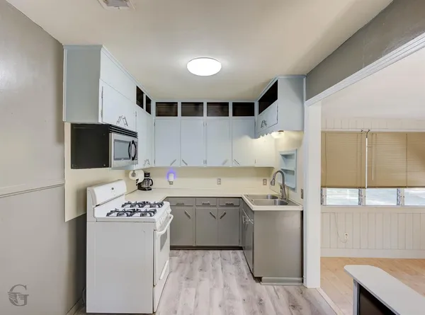 a kitchen with a sink stove and microwave