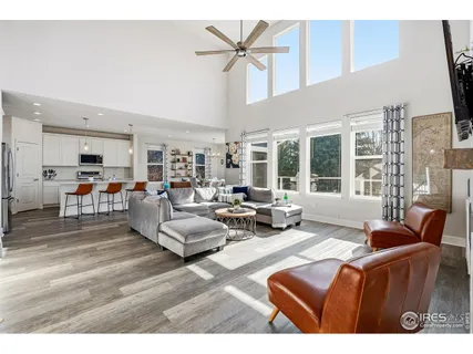 a living room with furniture kitchen view and a large window