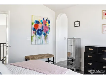 a bedroom with a bed and a painting on the wall