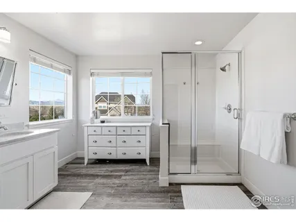 a bathroom with a granite countertop sink a mirror and a bathtub