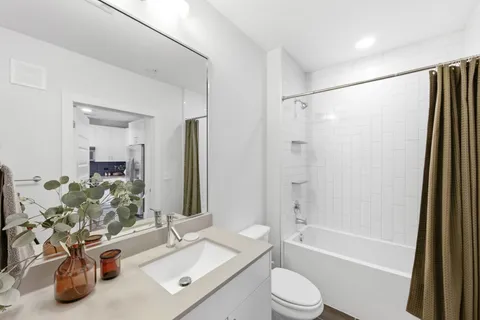 a bathroom with a sink vanity mirror and toilet