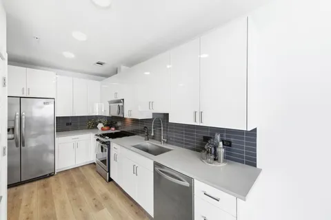 a kitchen with stainless steel appliances a sink stove and refrigerator