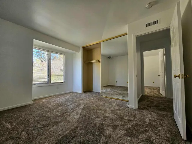 an empty room with windows and closet