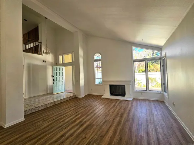 wooden floor fireplace and windows in an empty room