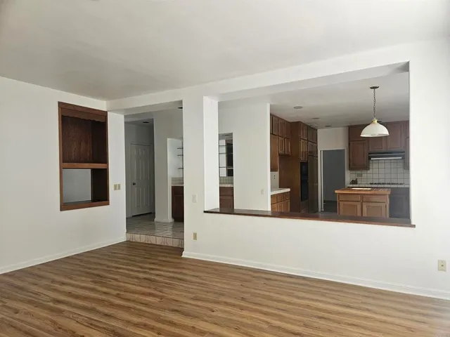 a view of a living room with furniture and wooden floor