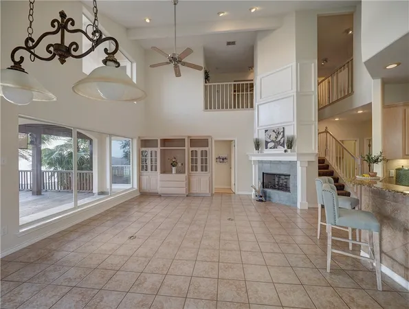 an empty room with windows and fireplace