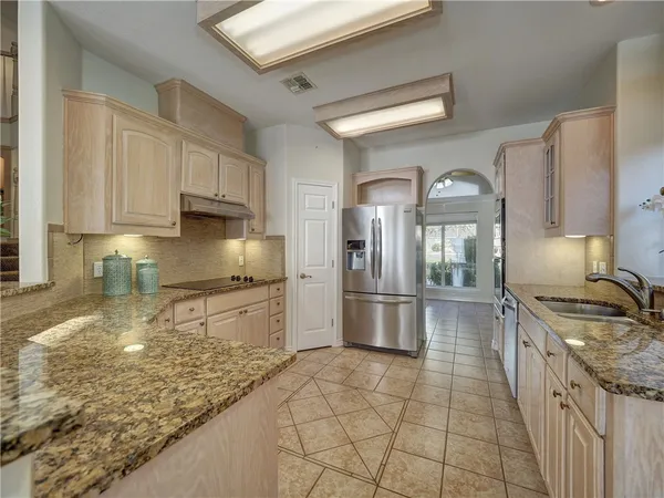 a kitchen with stainless steel appliances granite countertop a sink stove and refrigerator