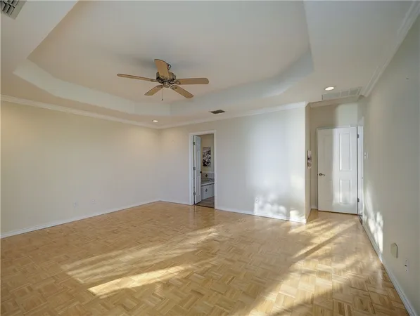 a view of a livingroom with a chandelier fan and windows