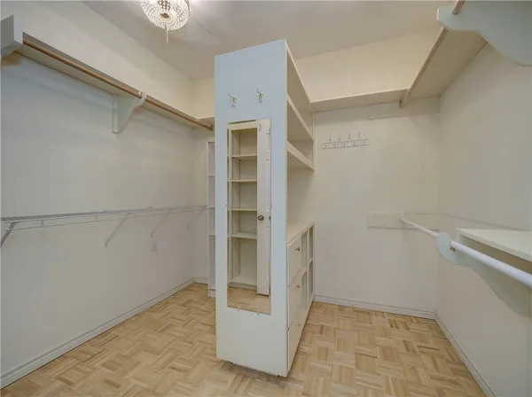 an empty room with chandelier fan and windows