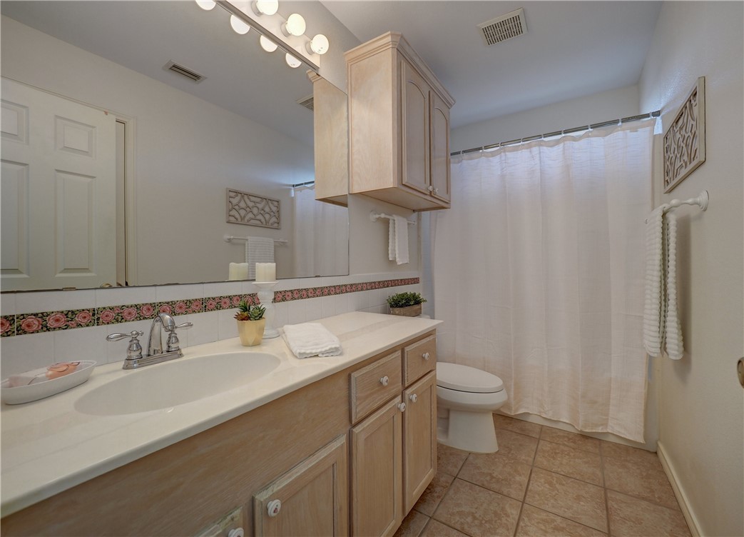 1343 Bayview Drive Portland, TX 78374 - Photo 30 of 36 a bathroom with a double vanity sink toilet and a mirror