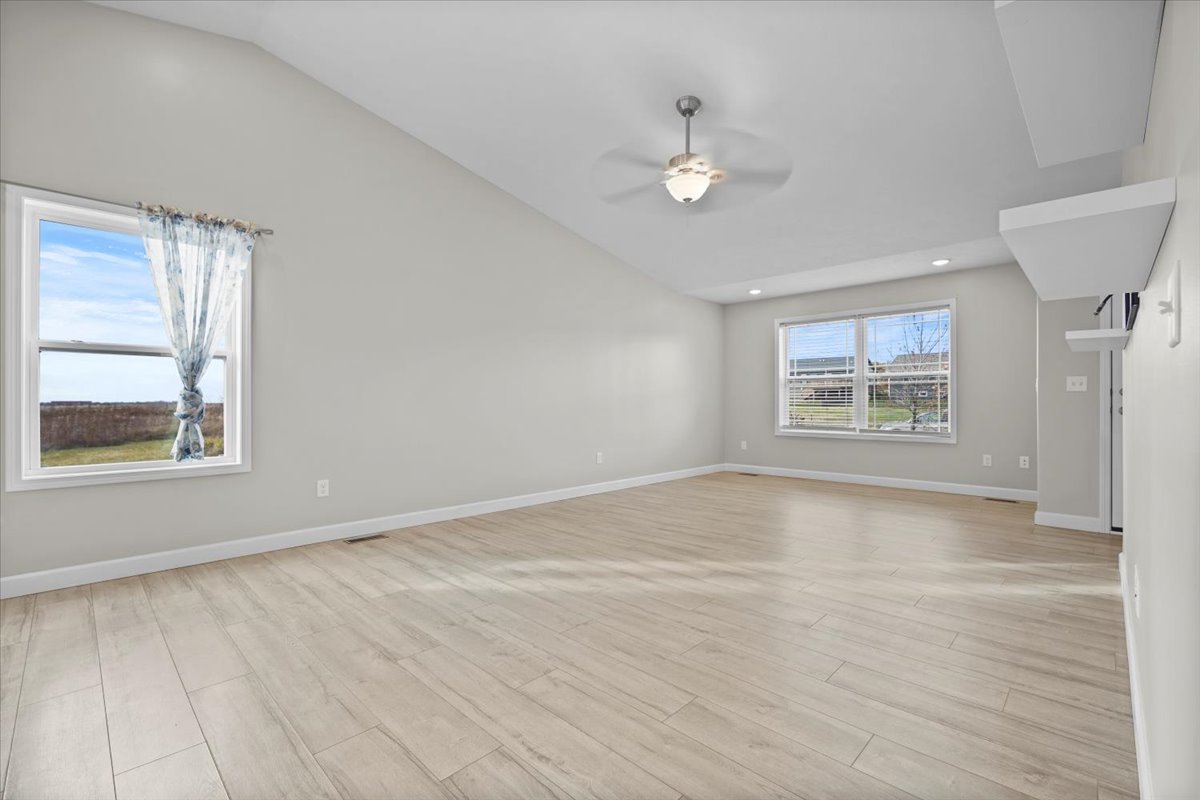 52 Winding Way Bloomington, IL 61705 - Photo 15 of 51 a view of an empty room with a window and wooden floor