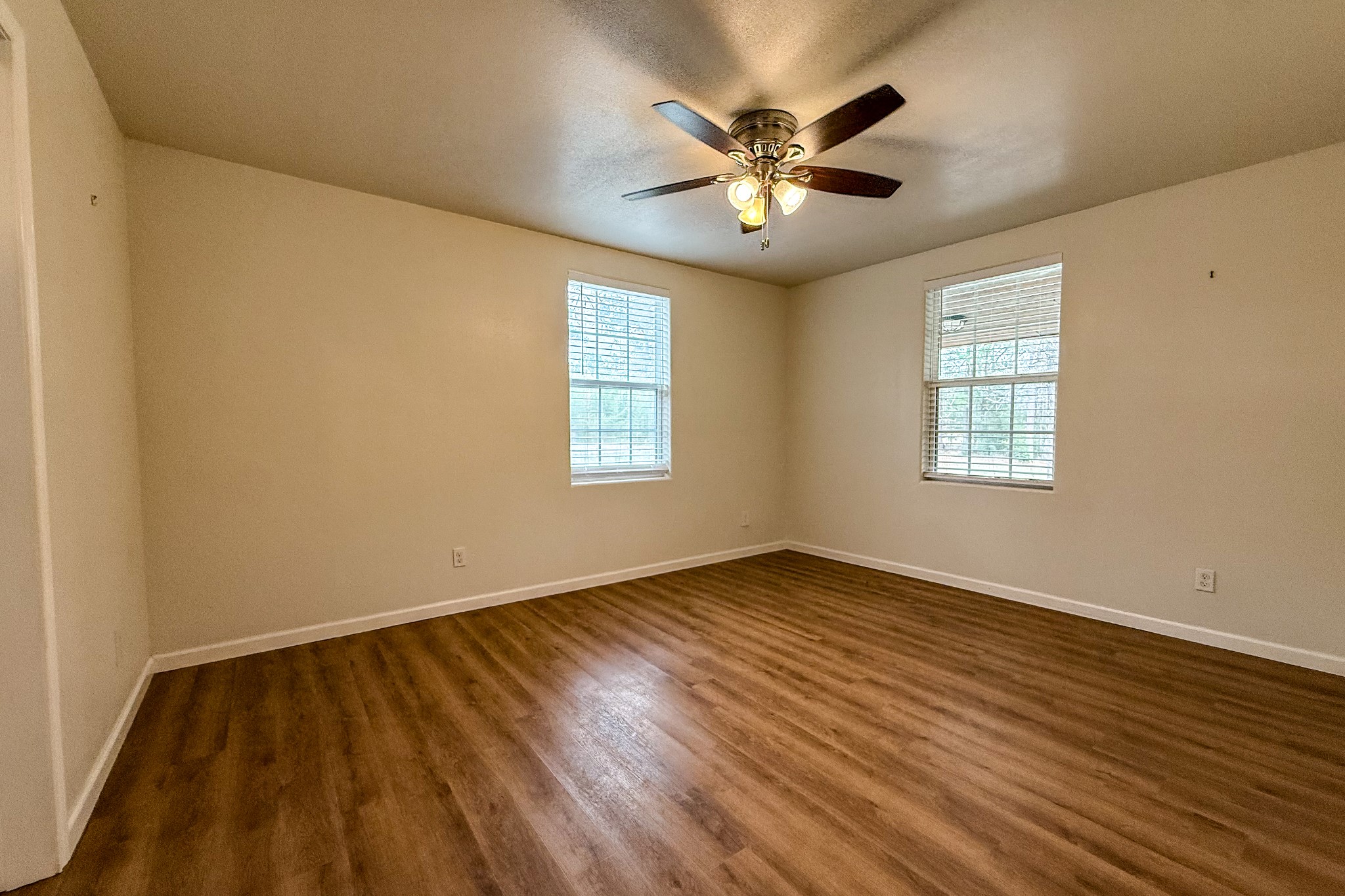 52 C Hank Benge Road Huntsville, TX 77320 - Photo 11 of 24 a view of an empty room with chandelier and wooden floor