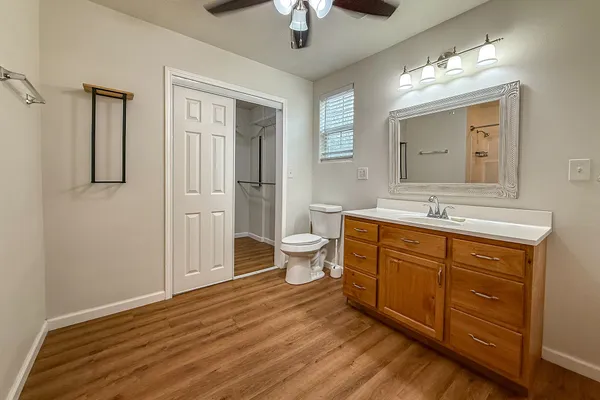 a spacious bathroom with a double vanity sink a large mirror and toilet