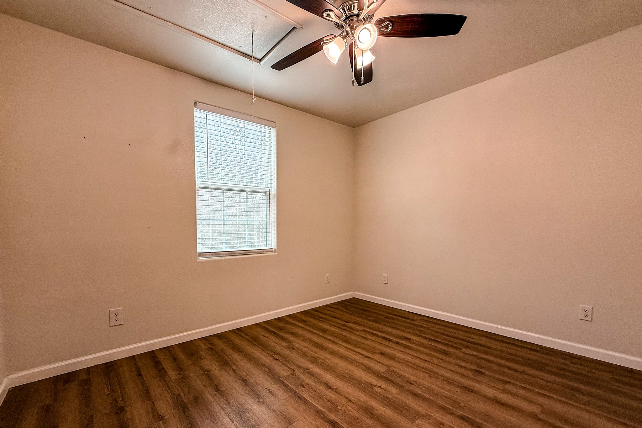 52 C Hank Benge Road Huntsville, TX 77320 - Photo 19 of 24 an empty room with wooden floor and windows