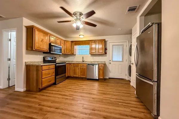 a kitchen with stainless steel appliances a refrigerator sink and microwave