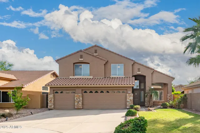 a front view of a house with a yard and trees