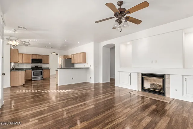 an empty room with fan and windows
