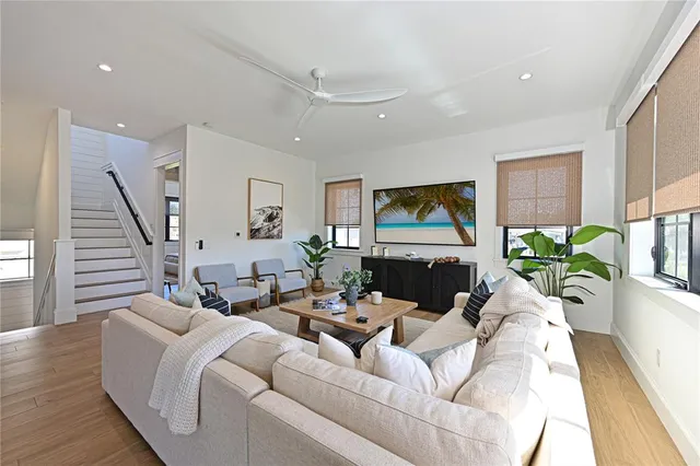 a open kitchen with stainless steel appliances granite countertop a stove a kitchen island a dining table and chairs with wooden floor