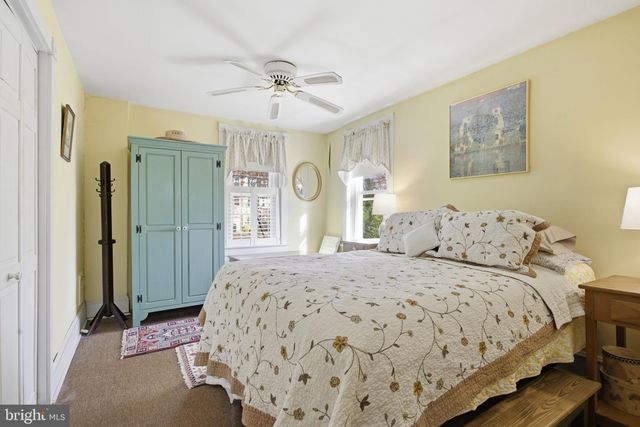 a bedroom with a bed and a lamp on dresser