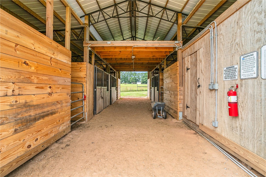 615 Wilson Road Central, SC 29630 - Photo 31 of 50 An airy center-aisle horse barn features robust timber framing and durable metal roofing.