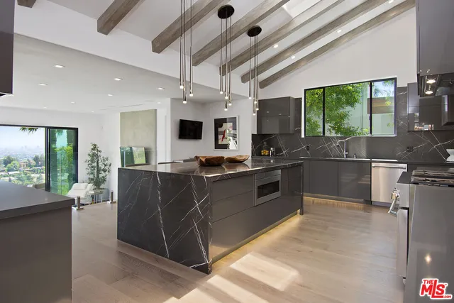 a kitchen with stainless steel appliances granite countertop a sink and a stove
