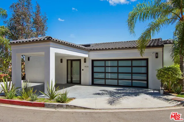 a front view of a house with plants