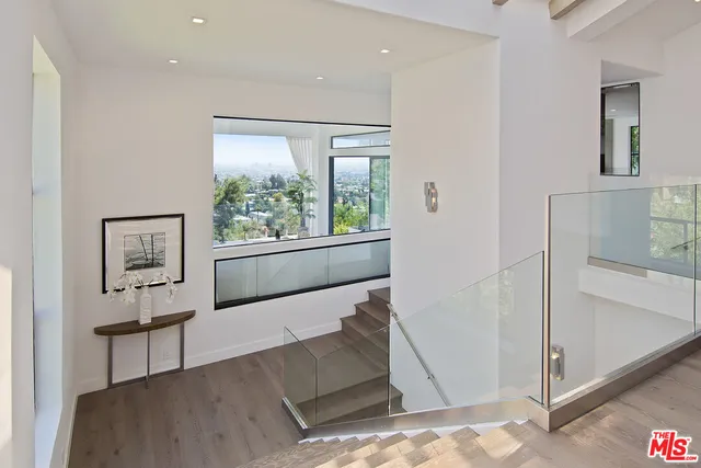 a bedroom with furniture a large window and a fireplace