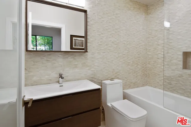 a large white bathroom with a large tub sink and shower