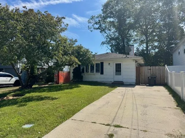 a front view of a house with a yard and trees