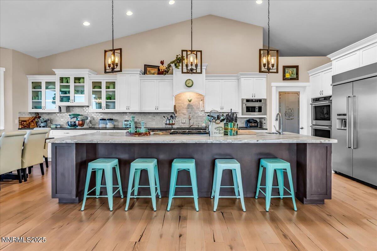 a kitchen with granite countertop lots of wooden furniture stainless steel appliances and wooden floor