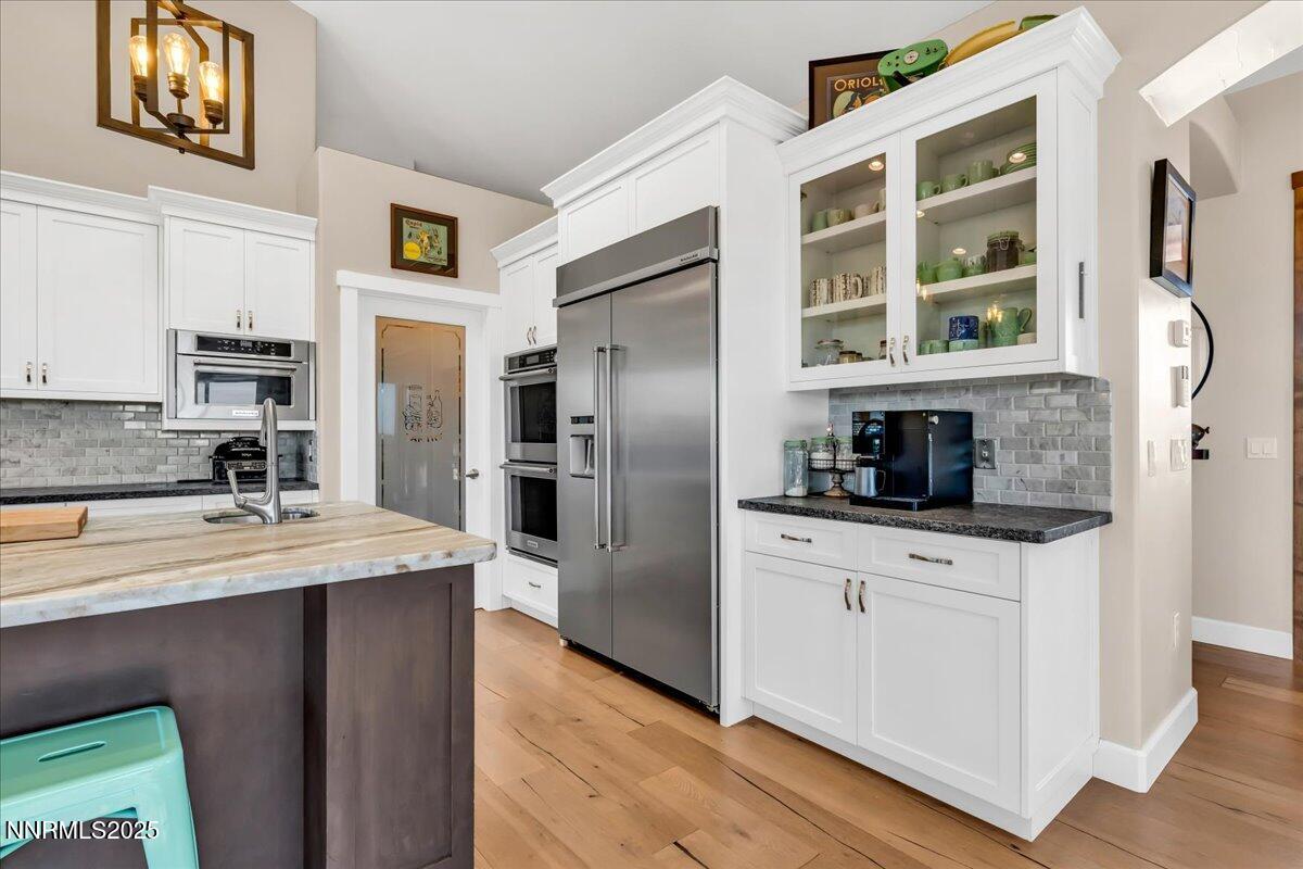 4610 Tybo Road Reno, NV 89521 - Photo 11 of 47 a kitchen with stainless steel appliances granite countertop a refrigerator a stove and a sink with wooden floor